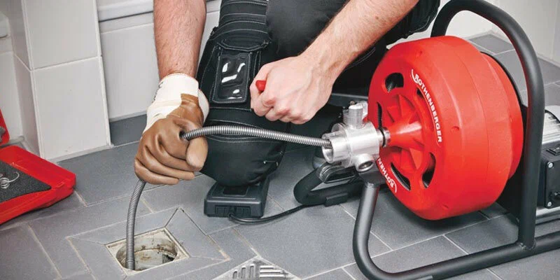 Plumber using a drain-cleaning machine in Rockledge